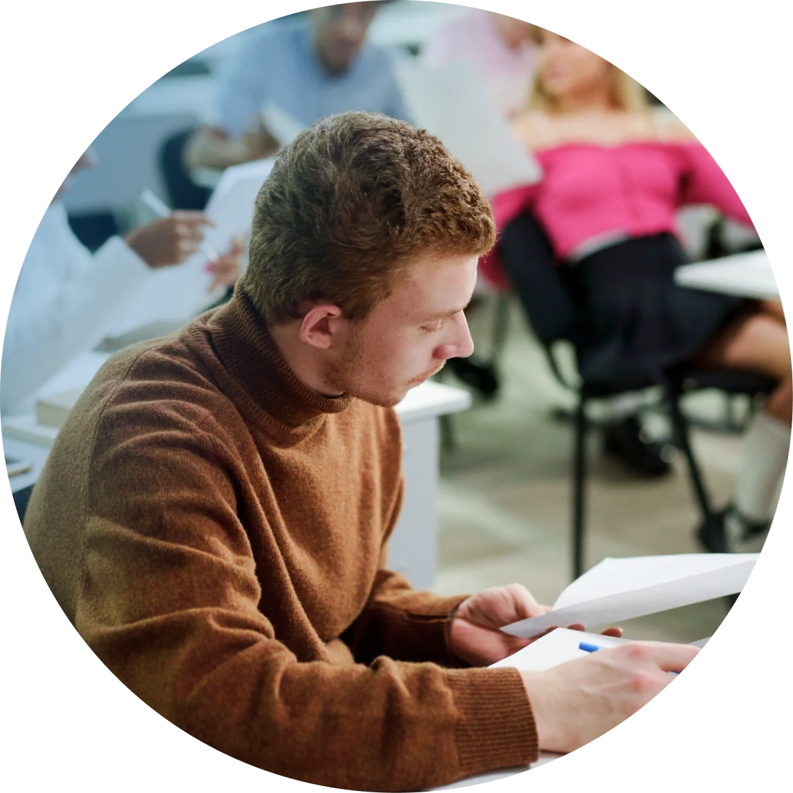 Student in a classroom reading a paper