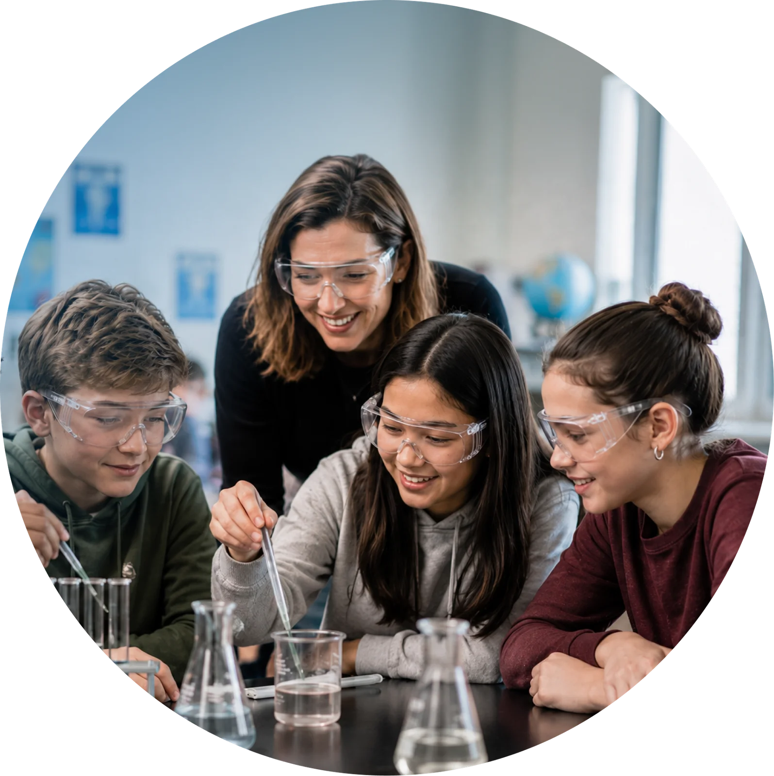 Teacher and students in safety goggles doing a chemistry experiment